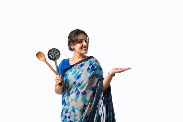 台所で見られるインドのアジア人女性の肖像画 木製の柄杓 ベラン へらまたは鍋を保持し 白い背景に対して隔離された — ストック写真