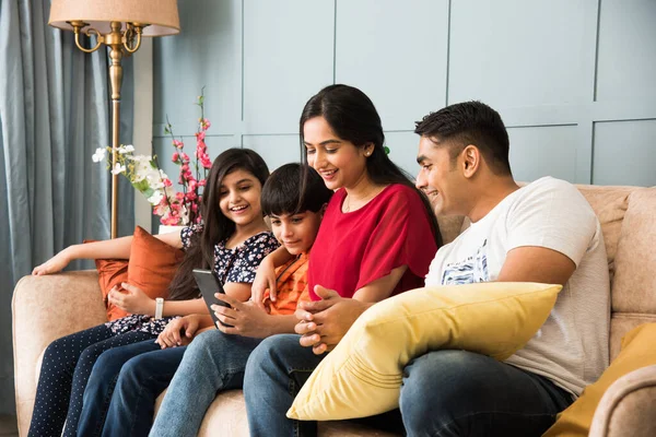 Indická Rodina Sedí Pohovce Pomocí Smartphonu Notebooku Nebo Tabletu Sledování — Stock fotografie