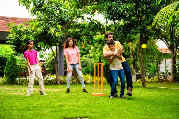 200 karakterli Hintli aile ev bahçesinde kriket oynuyor, açık hava sporları oynayarak kaliteli zaman geçiriyor, neşeli Asyalı ebeveynler ve çocuklar güneşli bir günde arka bahçedeki aktivitelerin keyfini çıkarıyorlar.