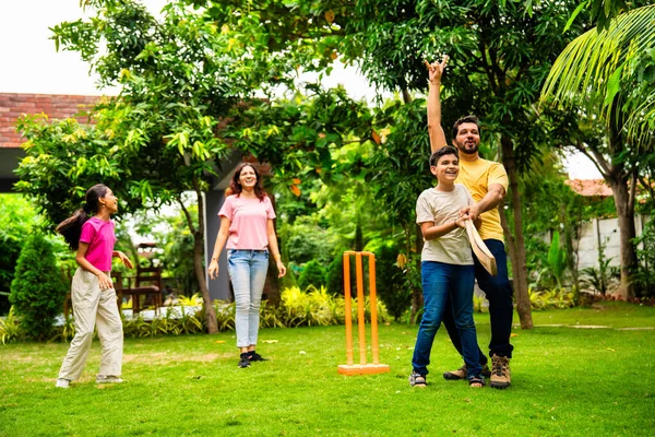 200 karakterli Hintli aile ev bahçesinde kriket oynuyor, açık hava sporları oynayarak kaliteli zaman geçiriyor, neşeli Asyalı ebeveynler ve çocuklar güneşli bir günde arka bahçedeki aktivitelerin keyfini çıkarıyorlar.
