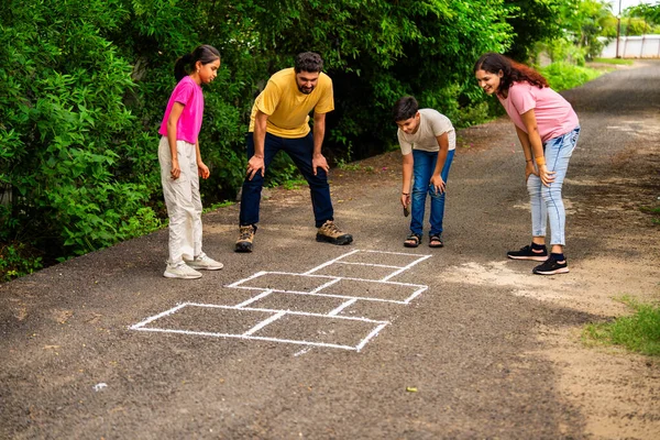 Ev bahçesinde geleneksel bir seksek oyunu olan Tikkar Billa ailesi, çocuklarla meydanda zıplayarak ve nostaljik açık hava sporlarının keyfini çıkararak kaliteli zaman geçiriyor.