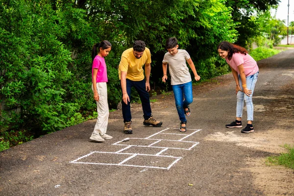 Ev bahçesinde geleneksel bir seksek oyunu olan Tikkar Billa ailesi, çocuklarla meydanda zıplayarak ve nostaljik açık hava sporlarının keyfini çıkararak kaliteli zaman geçiriyor.
