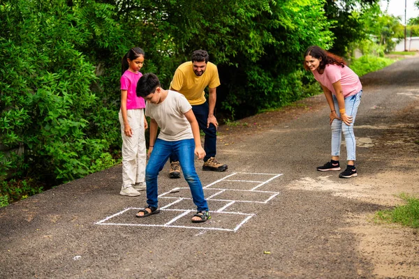 Ev bahçesinde geleneksel bir seksek oyunu olan Tikkar Billa ailesi, çocuklarla meydanda zıplayarak ve nostaljik açık hava sporlarının keyfini çıkararak kaliteli zaman geçiriyor.