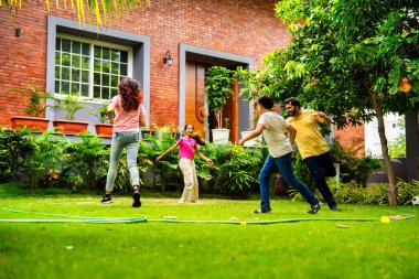 Ev bahçesinde Langdi oyunu oynayan Hintli bir aile, açık hava sporlarından zevk alarak birlikte kaliteli zaman geçiriyorlar, geleneksel Hint takım oyununda tek ayak üzerinde zıplayıp çeviklik tabanlı oyunu birleştiriyorlar.