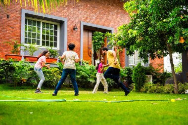 Ev bahçesinde Langdi oyunu oynayan Hintli bir aile, açık hava sporlarından zevk alarak birlikte kaliteli zaman geçiriyorlar, geleneksel Hint takım oyununda tek ayak üzerinde zıplayıp çeviklik tabanlı oyunu birleştiriyorlar.