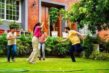 Ev bahçesinde Langdi oyunu oynayan Hintli bir aile, açık hava sporlarından zevk alarak birlikte kaliteli zaman geçiriyorlar, geleneksel Hint takım oyununda tek ayak üzerinde zıplayıp çeviklik tabanlı oyunu birleştiriyorlar.