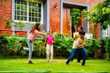 Ev bahçesinde Langdi oyunu oynayan Hintli bir aile, açık hava sporlarından zevk alarak birlikte kaliteli zaman geçiriyorlar, geleneksel Hint takım oyununda tek ayak üzerinde zıplayıp çeviklik tabanlı oyunu birleştiriyorlar.