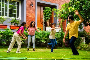 Ev bahçesinde Langdi oyunu oynayan Hintli bir aile, açık hava sporlarından zevk alarak birlikte kaliteli zaman geçiriyorlar, geleneksel Hint takım oyununda tek ayak üzerinde zıplayıp çeviklik tabanlı oyunu birleştiriyorlar.