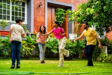 Ev bahçesinde Langdi oyunu oynayan Hintli bir aile, açık hava sporlarından zevk alarak birlikte kaliteli zaman geçiriyorlar, geleneksel Hint takım oyununda tek ayak üzerinde zıplayıp çeviklik tabanlı oyunu birleştiriyorlar.
