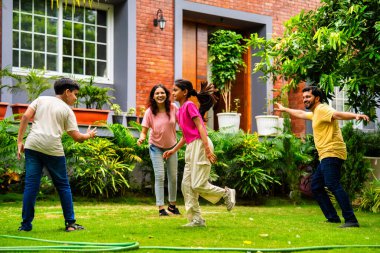 Ev bahçesinde Langdi oyunu oynayan Hintli bir aile, açık hava sporlarından zevk alarak birlikte kaliteli zaman geçiriyorlar, geleneksel Hint takım oyununda tek ayak üzerinde zıplayıp çeviklik tabanlı oyunu birleştiriyorlar.