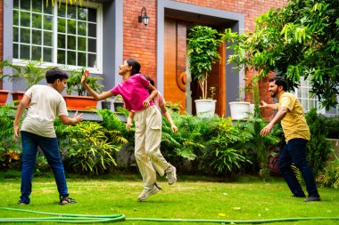 Ev bahçesinde Langdi oyunu oynayan Hintli bir aile, açık hava sporlarından zevk alarak birlikte kaliteli zaman geçiriyorlar, geleneksel Hint takım oyununda tek ayak üzerinde zıplayıp çeviklik tabanlı oyunu birleştiriyorlar.