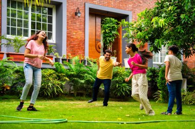 Ev bahçesinde Langdi oyunu oynayan Hintli bir aile, açık hava sporlarından zevk alarak birlikte kaliteli zaman geçiriyorlar, geleneksel Hint takım oyununda tek ayak üzerinde zıplayıp çeviklik tabanlı oyunu birleştiriyorlar.