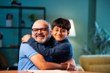 Hintli çocuk büyükbabaya evde sarılıyor. Büyükbaba masada otururken sevgi ve şefkat gösteriyor. Evde yaşlı bir adamla aile bağı kuruyor.