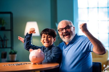 Hintli büyükbaba çocuklara evde kumbarada para biriktirmeyi öğretiyor, yaşlı adam torununa mali disiplin konusunda rehberlik ediyor, iyi para alışkanlığını güvence altına alıyor, aile bağlarını güvence altına alıyor.