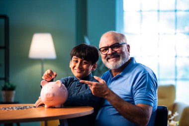 Hintli büyükbaba çocuklara evde kumbarada para biriktirmeyi öğretiyor, yaşlı adam torununa mali disiplin konusunda rehberlik ediyor, iyi para alışkanlığını güvence altına alıyor, aile bağlarını güvence altına alıyor.