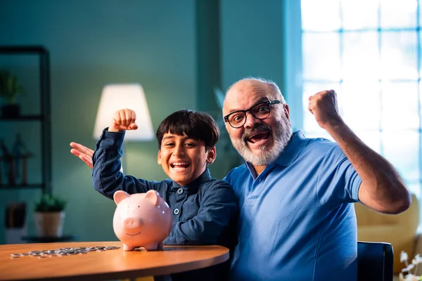 Hintli büyükbaba çocuklara evde kumbarada para biriktirmeyi öğretiyor, yaşlı adam torununa mali disiplin konusunda rehberlik ediyor, iyi para alışkanlığını güvence altına alıyor, aile bağlarını güvence altına alıyor.