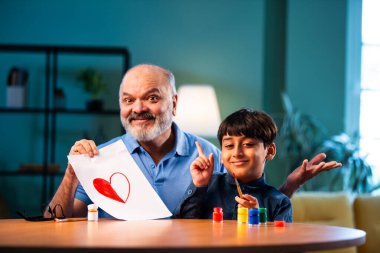 Hintli büyükbaba çocuğun kalbini fırça ve renkle boyamasına yardım ediyor. İkisi de modern evdeki masada birlikte oturuyor. Yaşlı adam torununa yaratıcı sanat eserlerinde rehberlik ediyor.