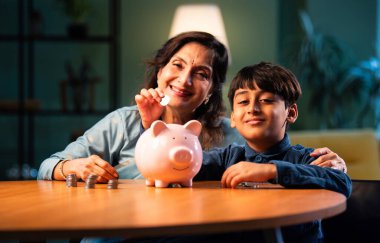 Hintli büyükannem çocuklara para biriktirmeyi öğretiyor. Modern evlerin masalarında para biriktiriyorlar. Yaşlı bir kadın torununa para biriktirme alışkanlığı ile mali eğitim veriyor.