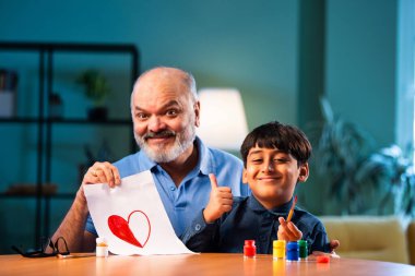 Hintli büyükbaba çocuğun kalbini fırça ve renkle boyamasına yardım ediyor. İkisi de modern evdeki masada birlikte oturuyor. Yaşlı adam torununa yaratıcı sanat eserlerinde rehberlik ediyor.