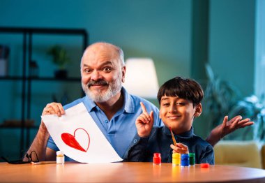 Hintli büyükbaba çocuğun kalbini fırça ve renkle boyamasına yardım ediyor. İkisi de modern evdeki masada birlikte oturuyor. Yaşlı adam torununa yaratıcı sanat eserlerinde rehberlik ediyor.