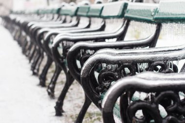 Kış sırasında içinde donmuş buz sarkıtları closeup perspektif görünüm seçici odak yeşil ahşap satır park banklar ile kaplı