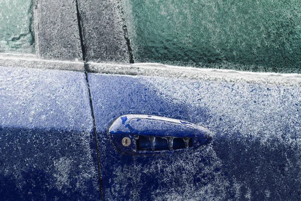 Önden görünüm portre mavi araba kapı kilidi ve buz sarkıtları ile kış sırasında dondurulmuş kulpu