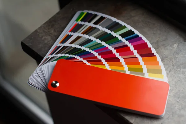 Vícebarevná barva papíru sampler otevřené na tmavý mramor — Stock fotografie