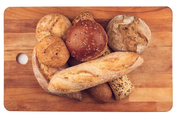 Diferentes tipos de pão na placa de corte de cozinha de madeira — Fotografia de Stock