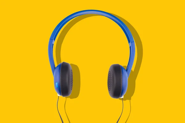 노란색 배경에 분리된 파란색 헤드폰 — 스톡 사진
