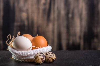 Menekşe, Paskalya için tasarım arka planı kavramı çiçeklerin örme çanta ahşap bir arka plan üzerinde renkli tavuk yumurtası yalan