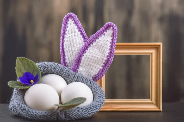Menekşe, Paskalya için tasarım arka planı kavramı çiçeklerin örme çanta ahşap bir arka plan üzerinde renkli tavuk yumurtası yalan