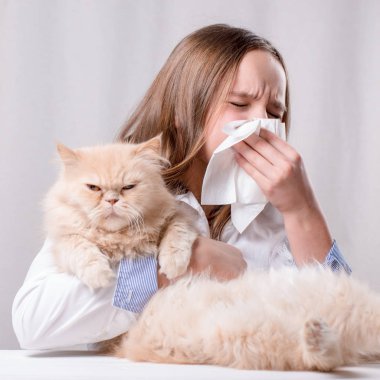 Burnuna bir eşarp üfleme ve bir kedi, bir saldırı ya da alerji belirtileri kavramı tutan genç kız