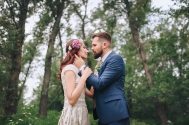 Çelenk kucaklayan ile gelin damat yaz ormandaki sakallı.