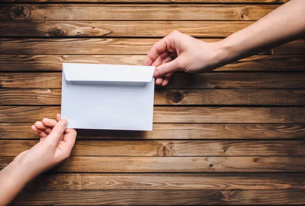 White envelope in hands of two people. Online donation. Concept of writing. Internet.