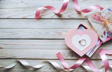 Evlilik teklifi kavramı. Bir hediye kutusu ahşap zemin üzerinde bir nikah yüzüğü. Sevgililer günü. Uzay kopyalayın. Üstten Görünüm.