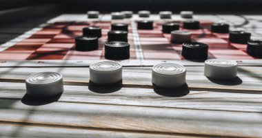 Pembe ve kırmızı hücreleri ile bir kağıt satranç taşları. Zor durum. Dört beyaz dama ön planda.