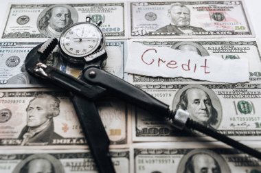 Dolar ve saat, bir İngiliz anahtarı klempe. Uluslararası Para Fonu için mali kölelik, kredi ve faiz ödemelerinin kavramı. Kağıt - kredi üzerinde yazıt.