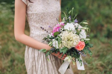 Gelinin ellerinde güzel bir düğün buketi. Beyaz ve pembe güller. Güzel Sanatlar.