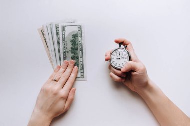 Usurer, kredi kavramı. Hızlı para için zaman. Beyaz arka plan üzerinde gri bir kronometre tutan kadının el. Dolar.