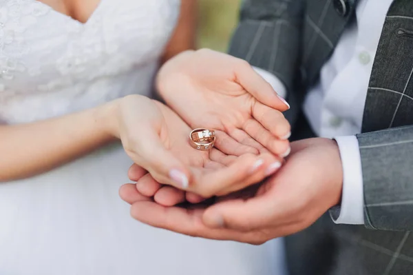 花嫁と新郎のヤシの木の つの結婚指輪です 花嫁と花婿の掌に式の間に結婚指輪を保持しています クローズ アップ — ストック写真