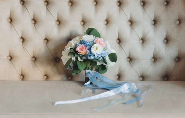 Wedding bouquet bride is lay on a sofa in the vintage interior. Close uop.