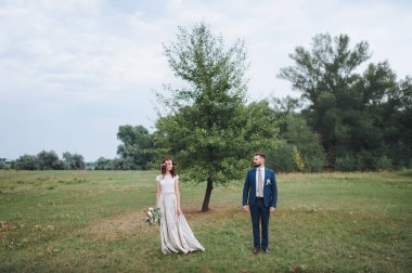 Gelin ve damat duran bir ağacı yakınındaki ve birbirinize bakın.