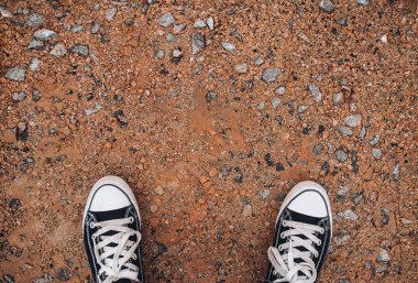 Çakıl taşlarında spor ayakkabılar. Uzayı kopyala Yürüyerek gidiyorum. Modern rahatlık.