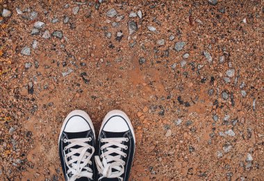 Sravel arka planda spor ayakkabıları. Yürüyüş ve spor konsepti.