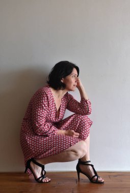 kadın oturma ura duvarın önünde çömelme.