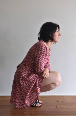 kadın oturma ura duvarın önünde çömelme.