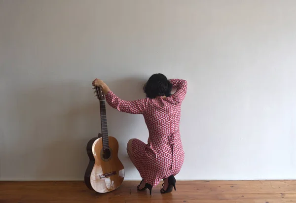 壁にギターを後ろから女性 — ストック写真