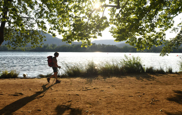 female hiker in front of a lake when evening