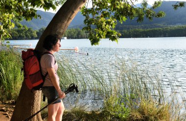 bir ağaç karşı yaslanmış ve gün batımını izlemek kadın