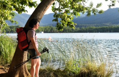 bir ağaç karşı yaslanmış ve gün batımını izlemek kadın